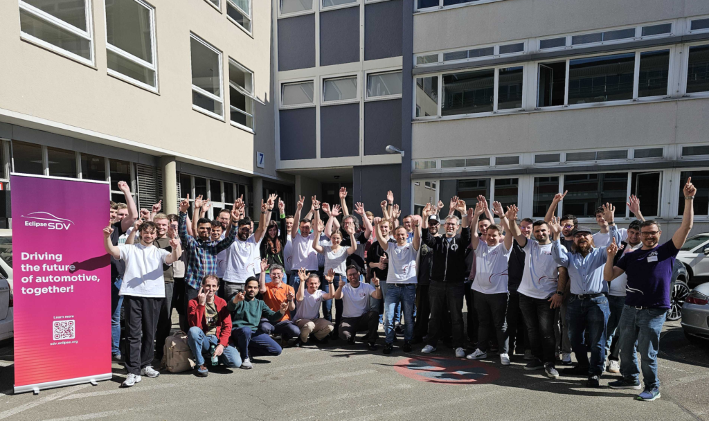 A group of people standing in front of a building, cheering at SDV HackFest
