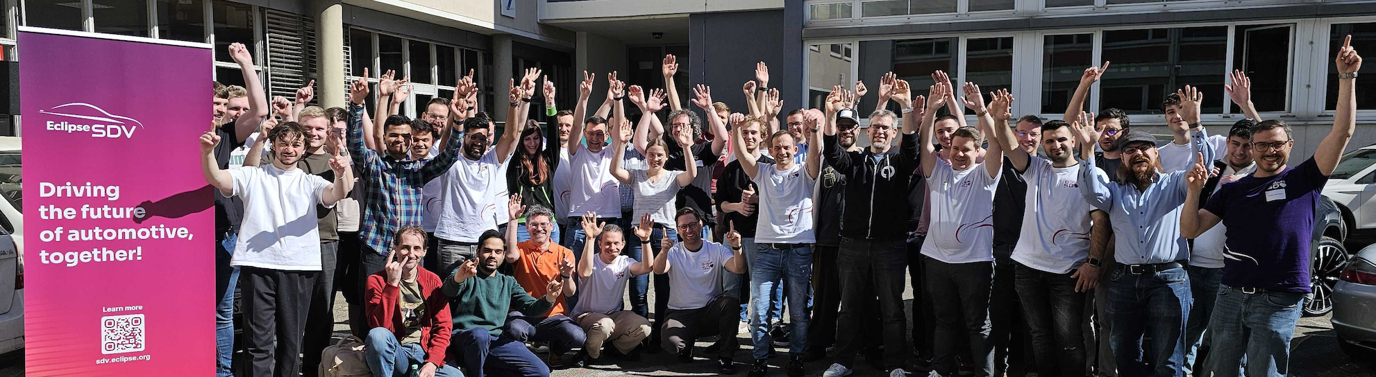 A group of people standing in front of a building at SDV HackFest, cheering