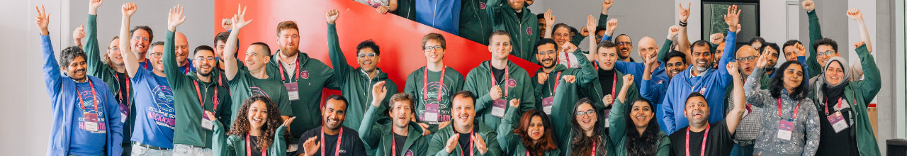 A large group of people standing in a hallway, waving at the camera at the Eclipse SDV Hackathon 2026.